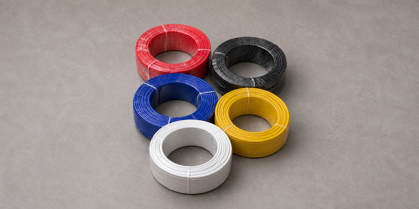 Five real shrink-wrapped HOLID FRPU tube coils in red, black, blue, yellow and white on an extended clean studio floor